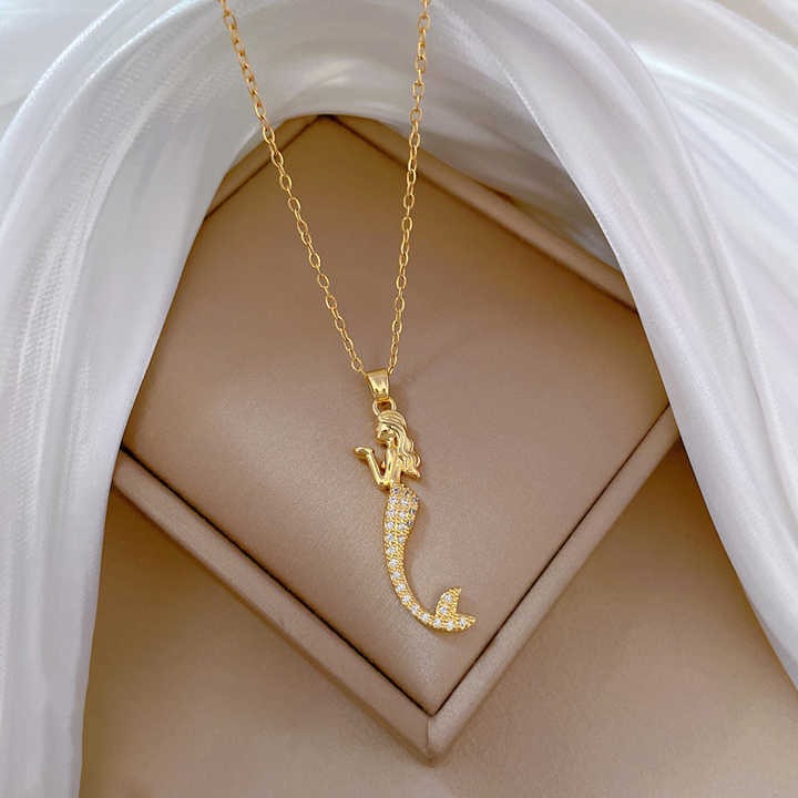 "Gold mermaid pendant necklace with crystal tail on soft satin box