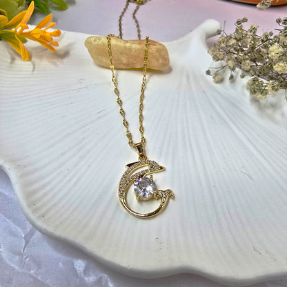 Close-up of Dolphin Pendant Chain on white shell background showcasing crystal-studded pendant.