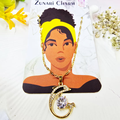 Necklace on Zunari Charm packaging card with gold chain and dolphin pendant.