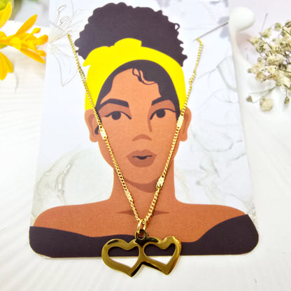 Twin Heart Necklace displayed on Zunari Charm packaging card with gold chain.