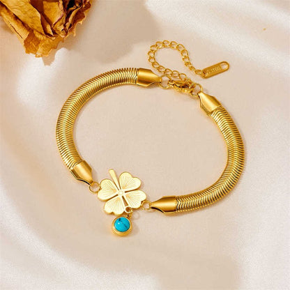 Elegant gold charm bracelet with turquoise evil eye charm on satin background