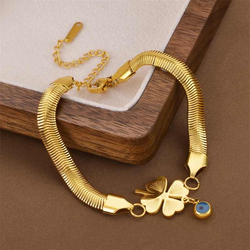 Premium gold snake bracelet with lucky clover charm on a velvet box