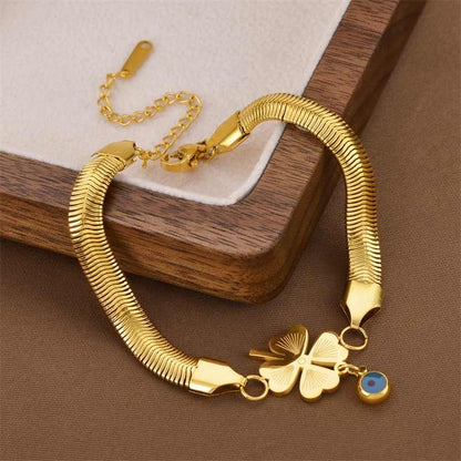 Premium gold snake bracelet with lucky clover charm on a velvet box