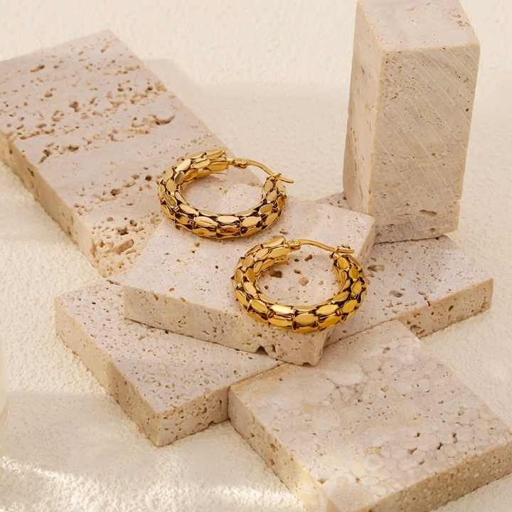 Artistic display of snake earrings with brick textures