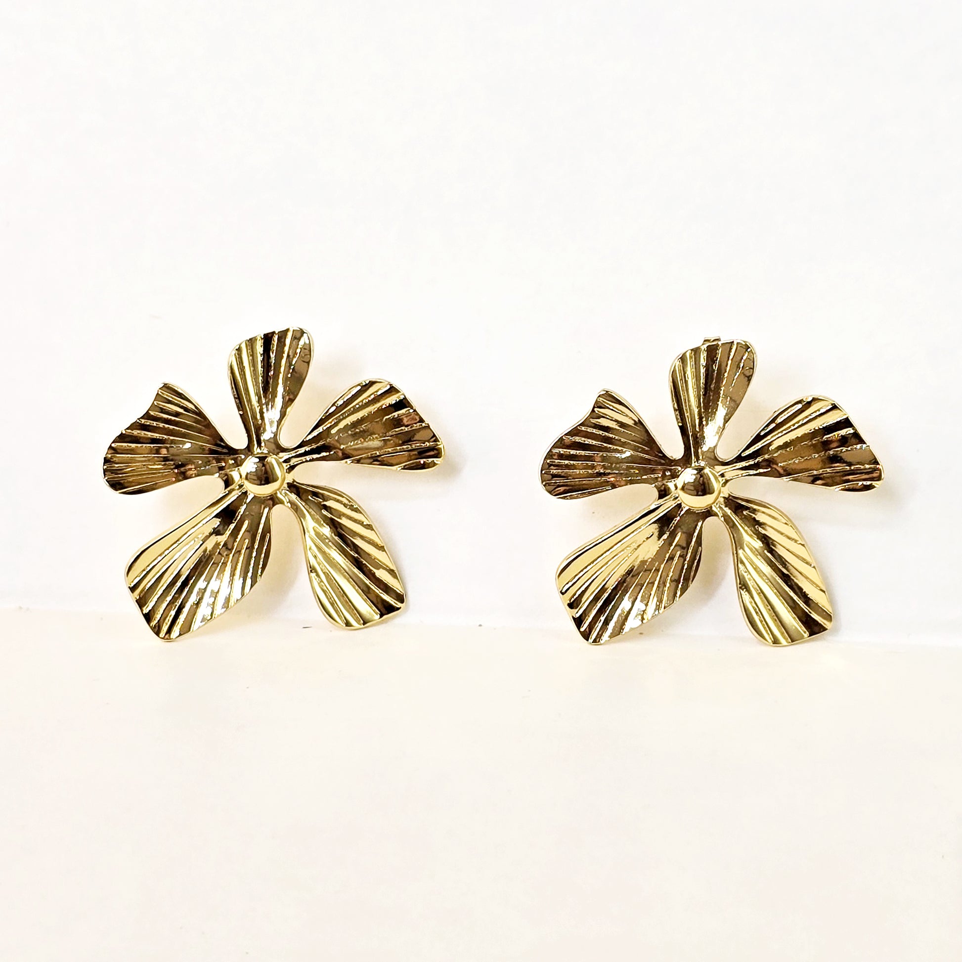 Textured gold flower earrings front view white background