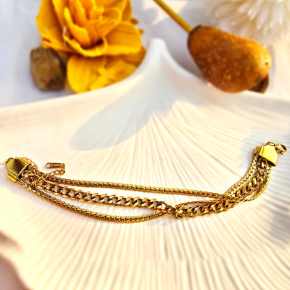 Aesthetic flat lay of the 3-in-1 layered gold bracelet on a white shell.