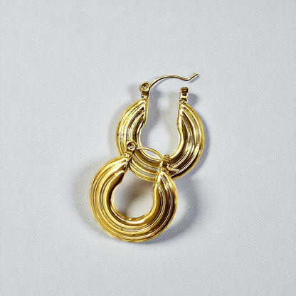 Groovy Earrings – pair of gold textured hoop earrings on white background