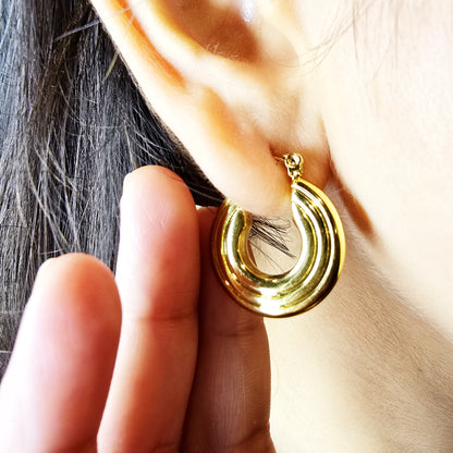 Groovy Earrings – model wearing gold textured hoop earrings close-up