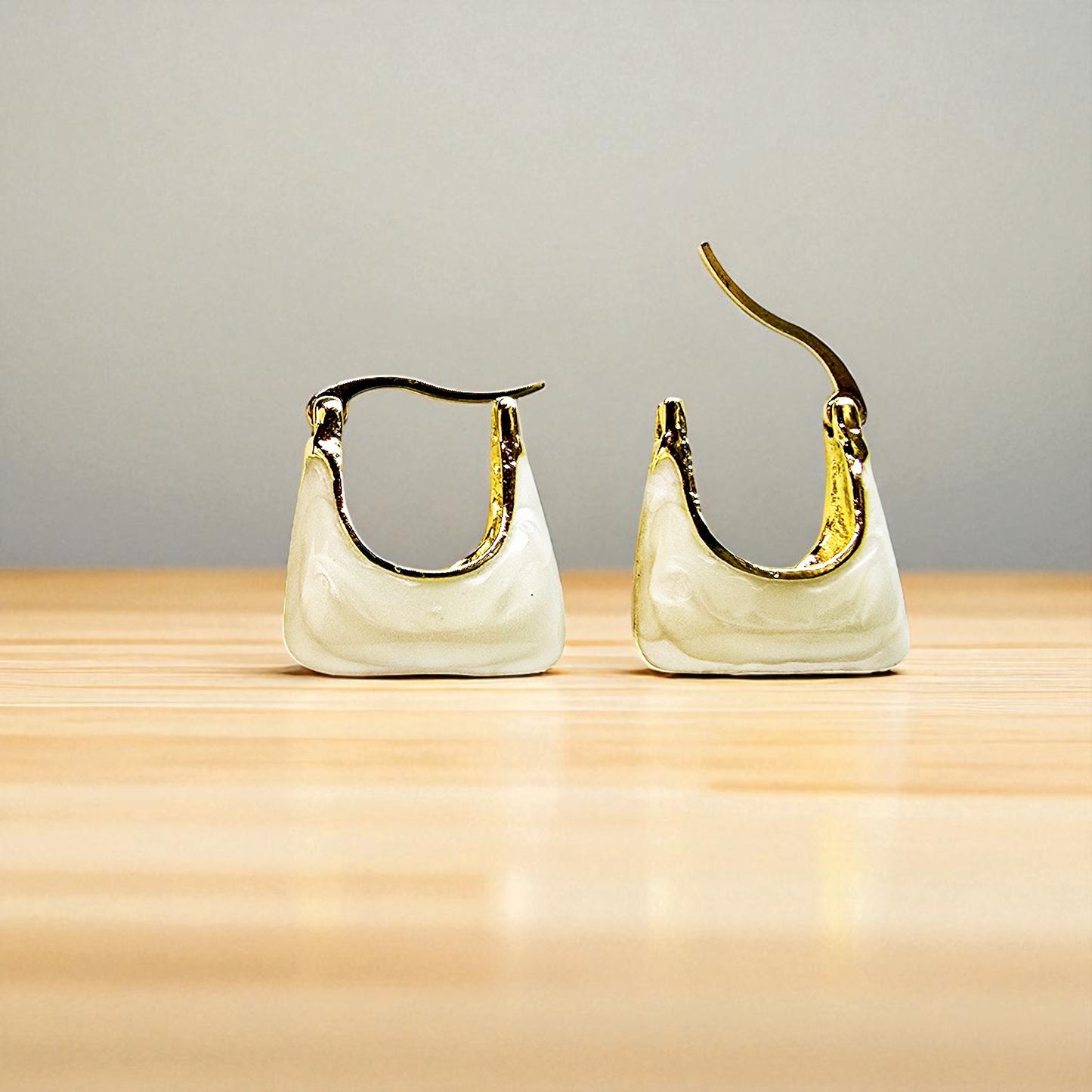 Handbag Earrings – ivory tote-style earrings on wooden surface