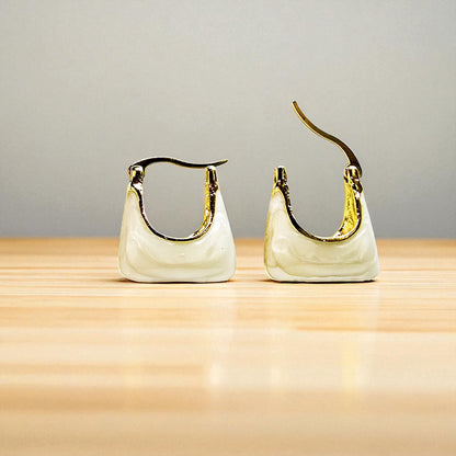 Handbag Earrings – ivory tote-style earrings on wooden surface