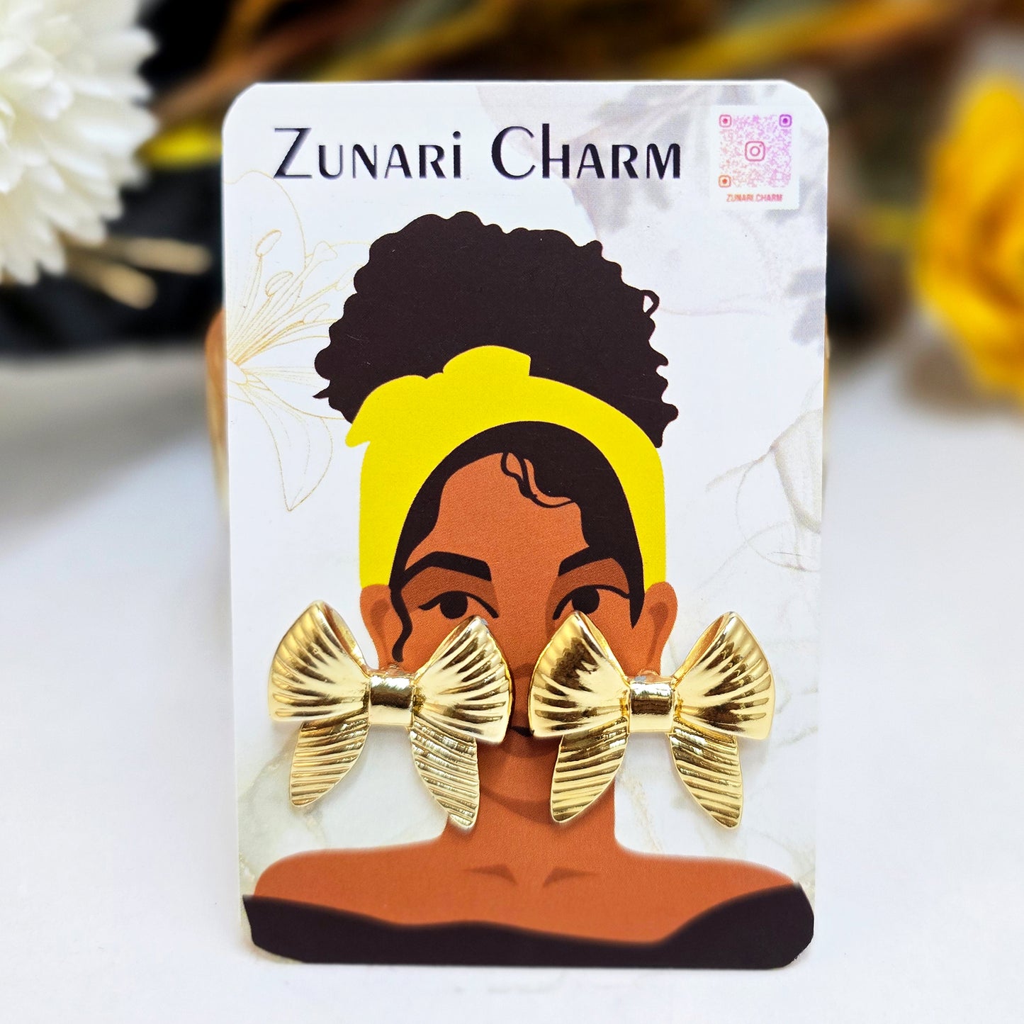 Gold Honey Bow studs presented on a Zunari Charm branded card featuring an illustrated woman with a yellow turban.