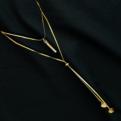 Layered Charm Drop Necklace flatlay on black fabric – chic and elegant