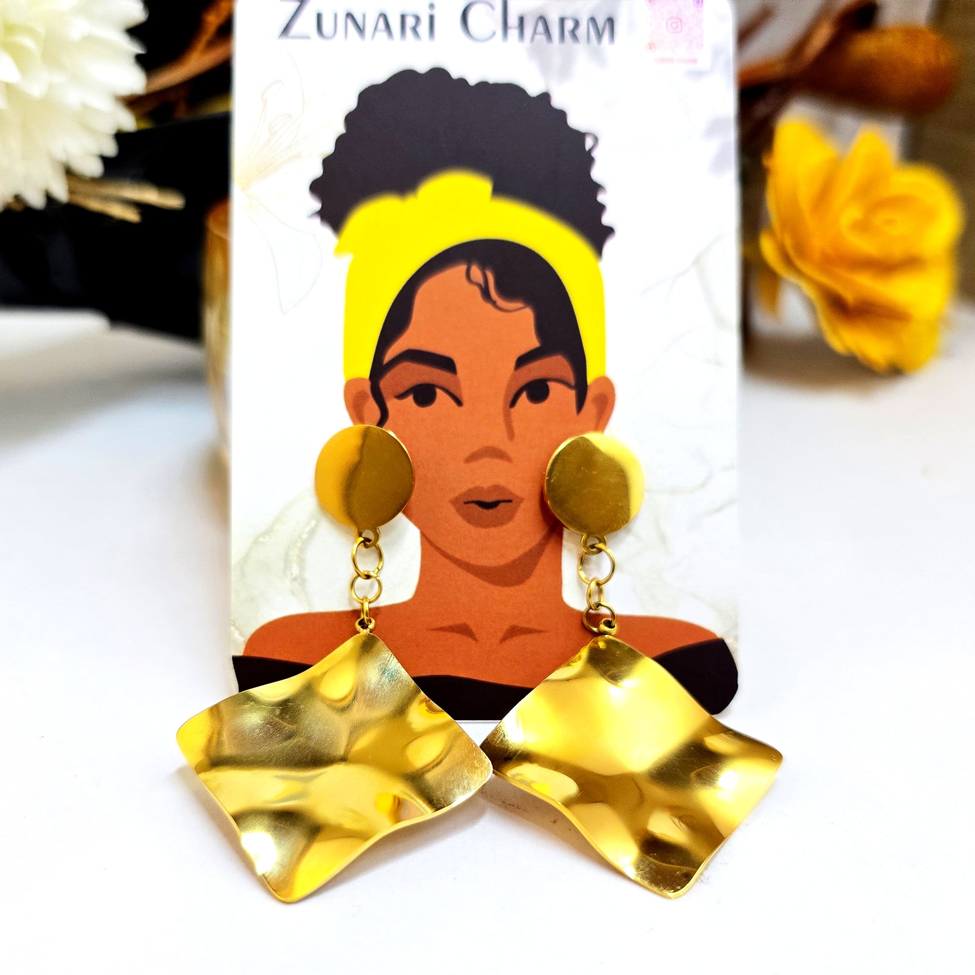 Zunari Charm branded earring card showing liquid gold square drops against an illustrated woman wearing a yellow turban.