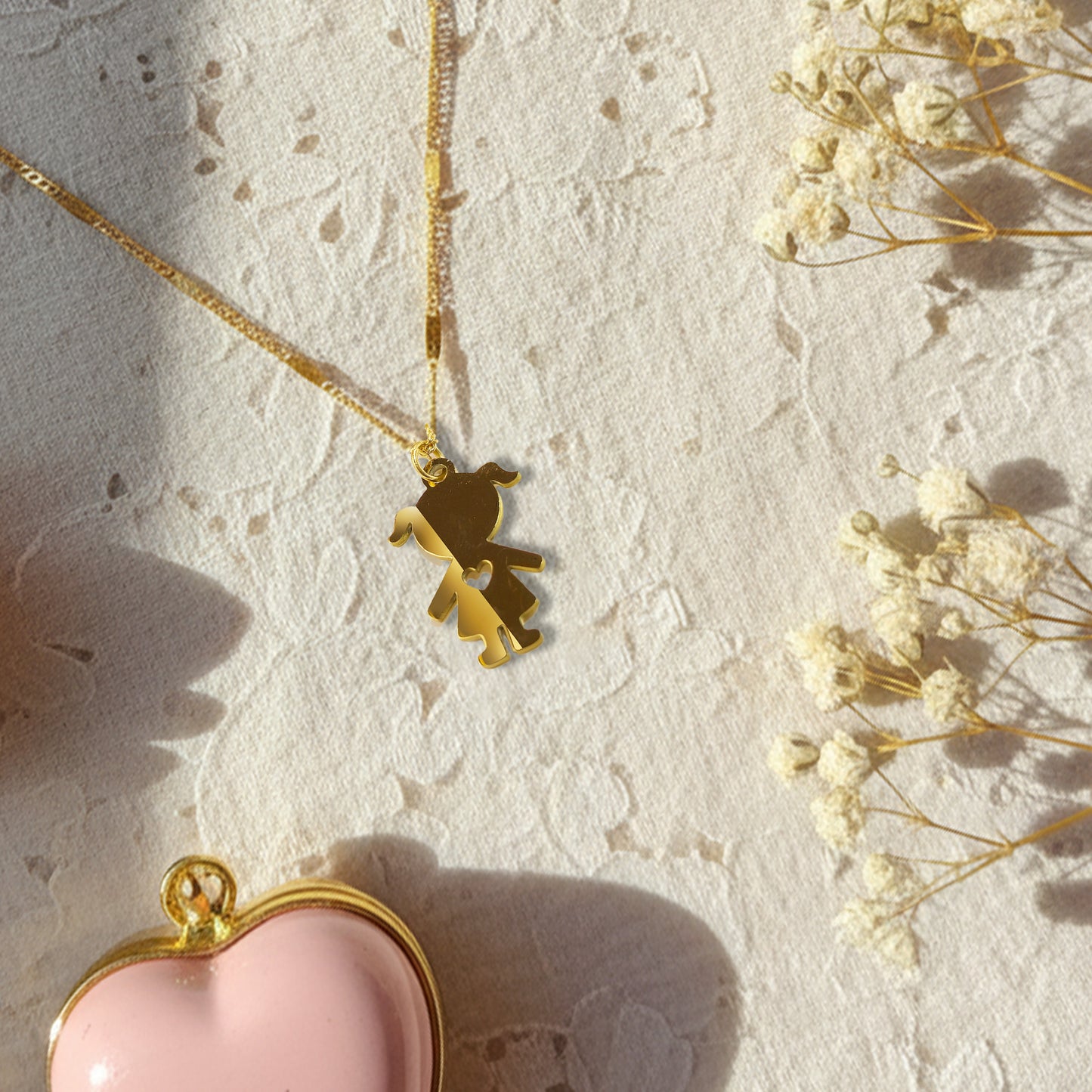 Sentimental little girl charm necklace shown on a textured white lace background in soft sunlight.