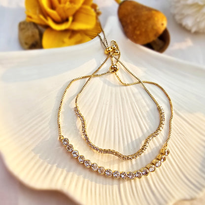 Flat lay of Lumière layered bracelet showing thin tennis chain and large crystal strand.