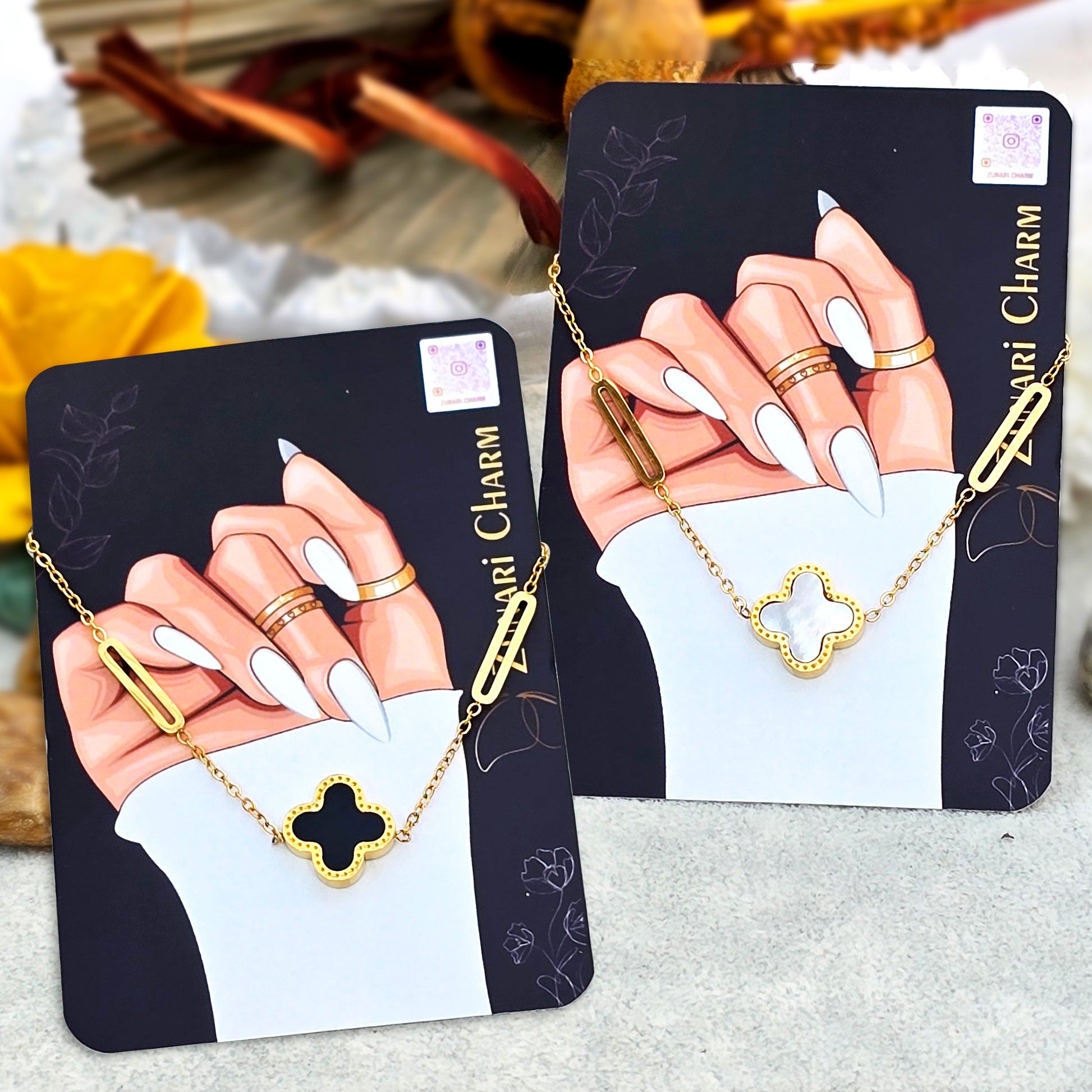 Two Zunari Charm packaging cards displaying the Black and White variants of the clover bracelet.