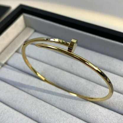 Gold nail bracelet displayed inside a luxury jewelry box