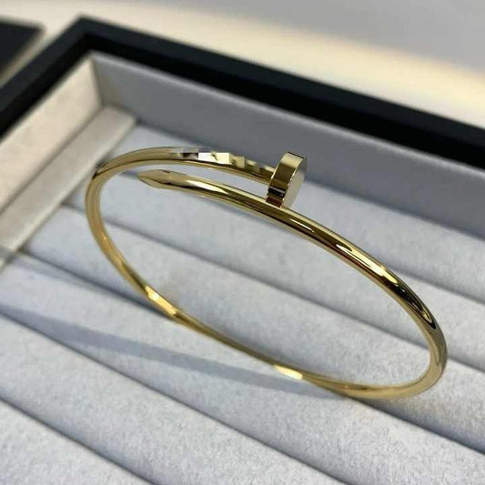 Gold nail bracelet displayed inside a luxury jewelry box