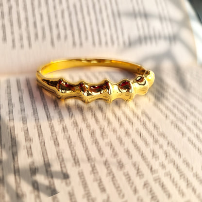 Gold statement bracelet with modern artistic silhouette