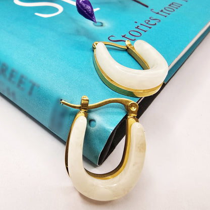 Moonlit Loop Earrings – chic ivory hoop earrings styled on a blue book