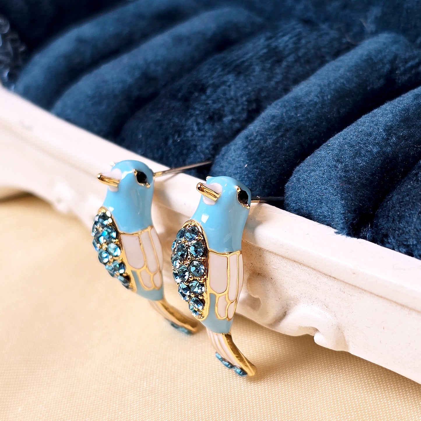 Bird earrings aesthetic display with velvet background