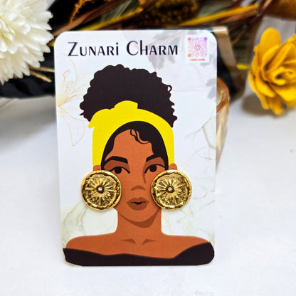 Nova Coin gold studs displayed on a Zunari Charm branded card featuring an illustrated woman with a yellow turban.