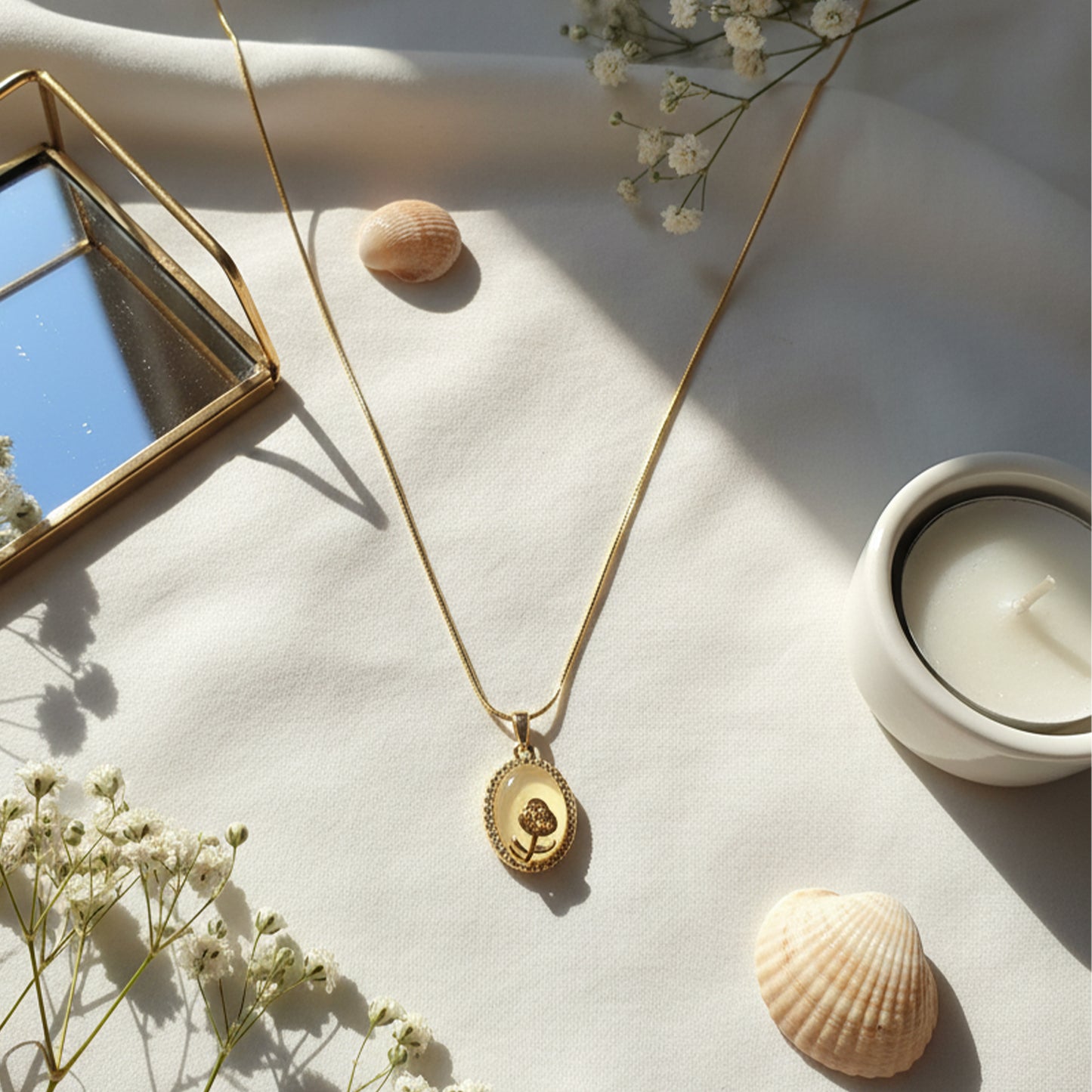 Opal Flower Pendant laid on cream fabric with seashells, candle & soft sunlight aesthetic.