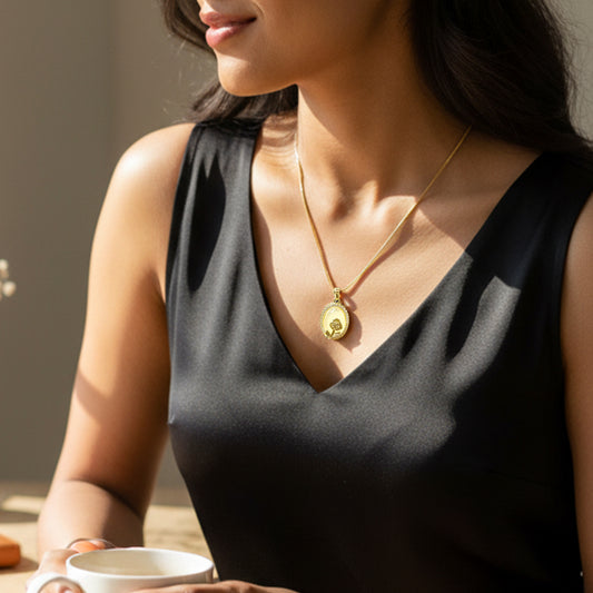 Model wearing Opal Flower Pendant Chain – gold necklace with oval floral pendant.