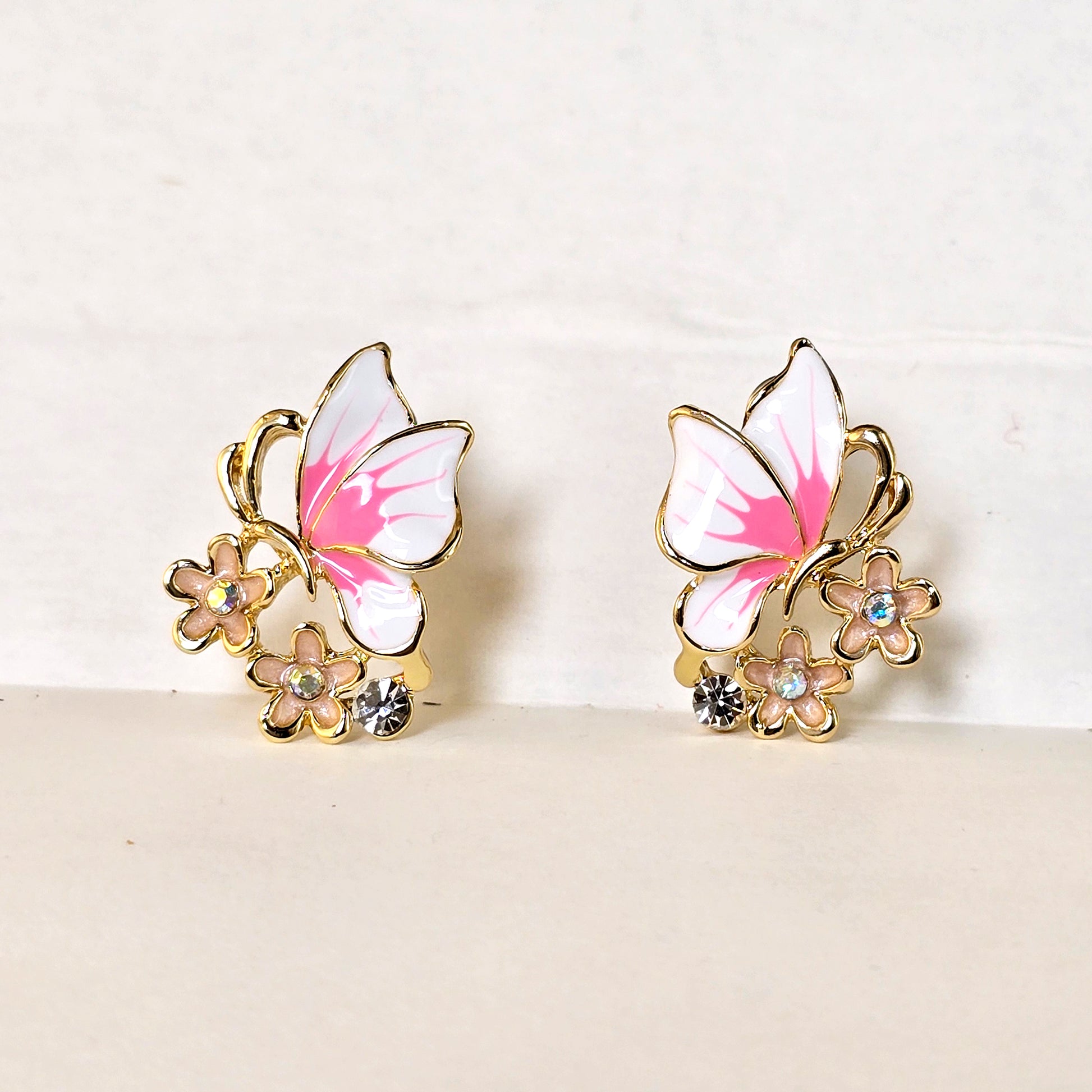 Pink butterfly enamel earrings with floral design front view