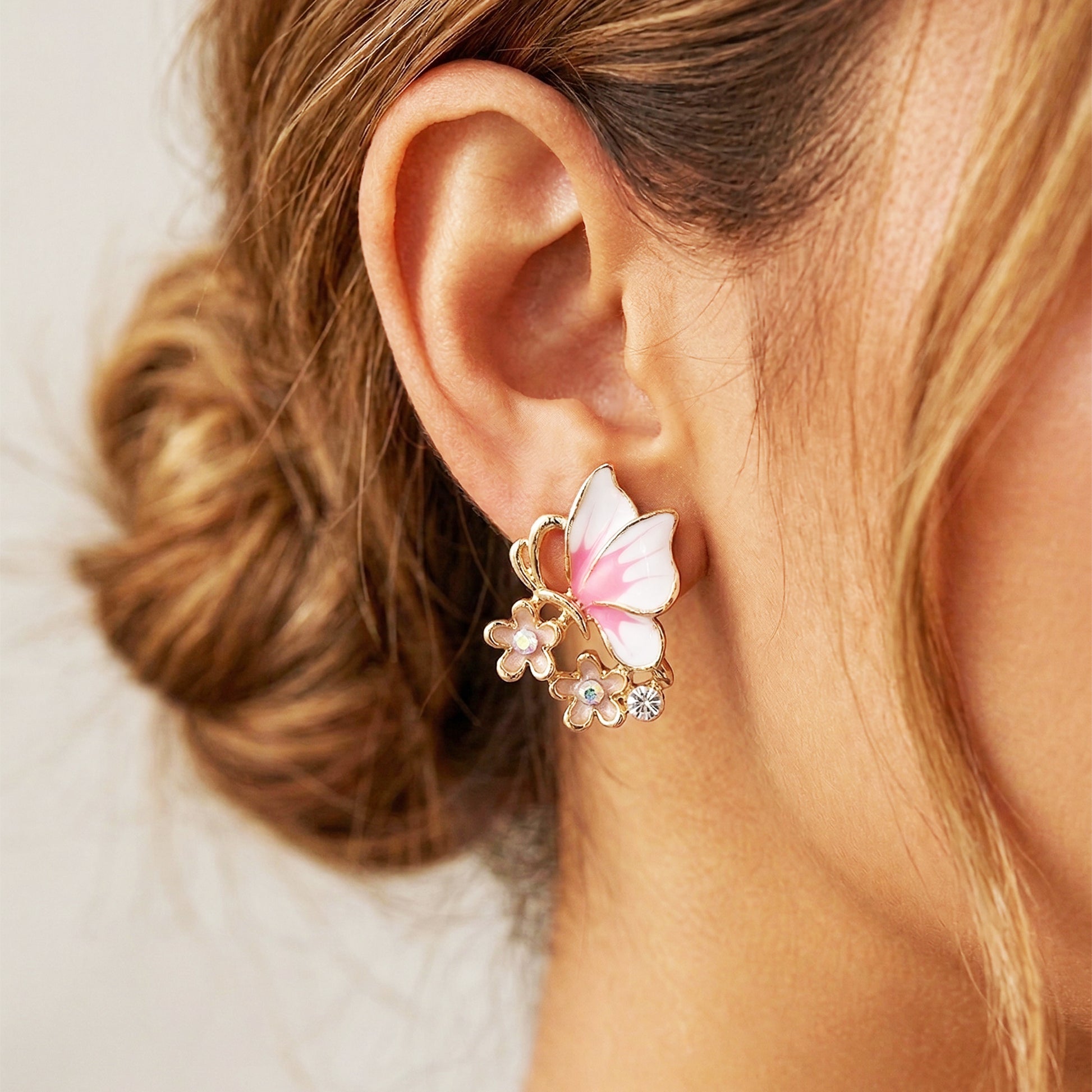 Pink butterfly earrings worn by model close-up