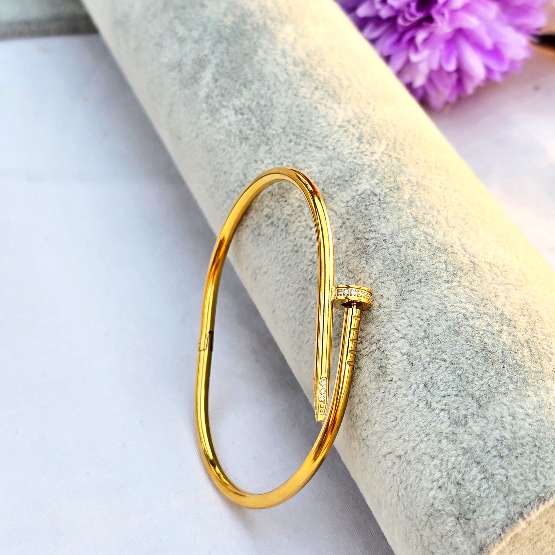 Side profile of gold nail bracelet showing crystal pavé details on the tip.