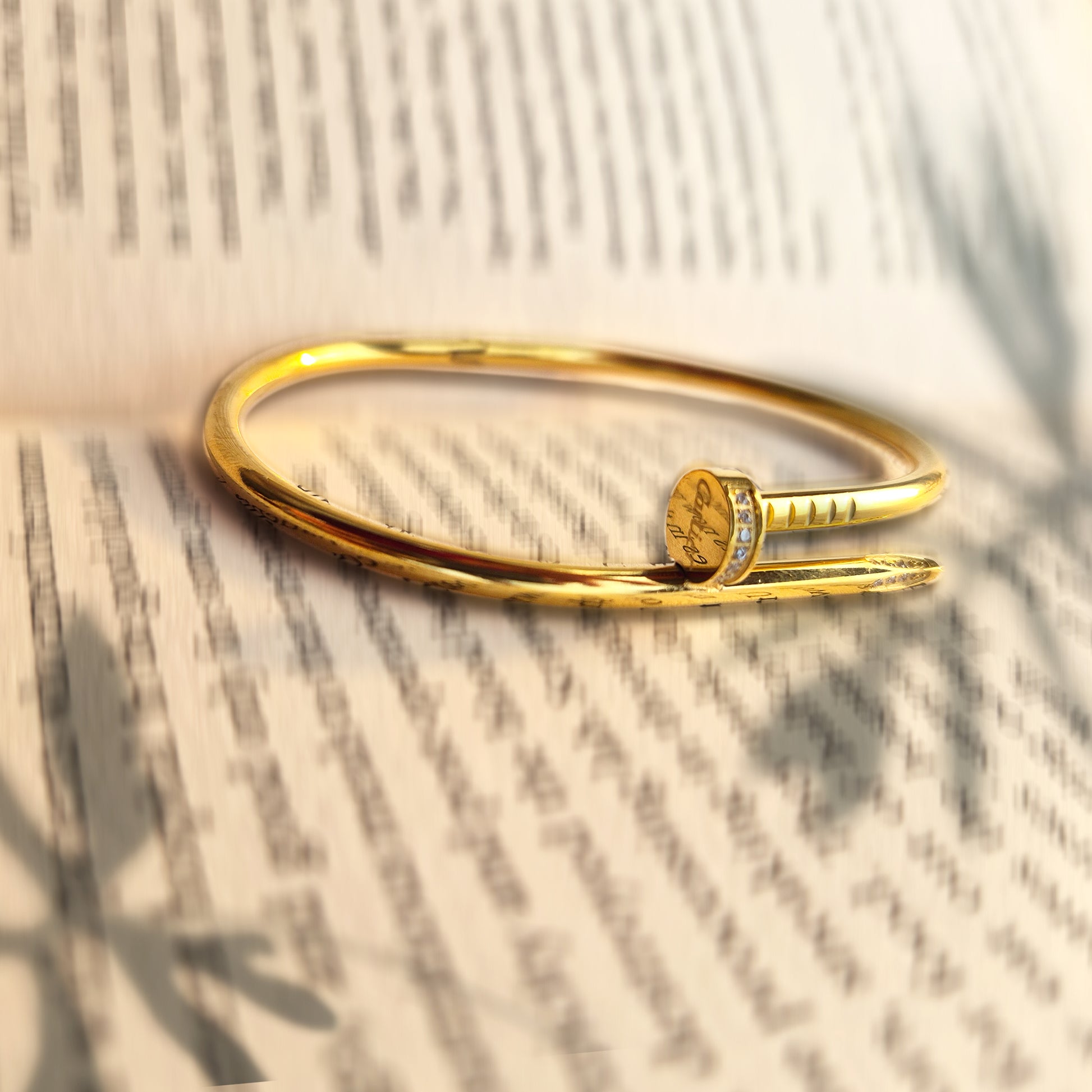 Close-up macro shot of crystals set into the head of a gold nail bangle.