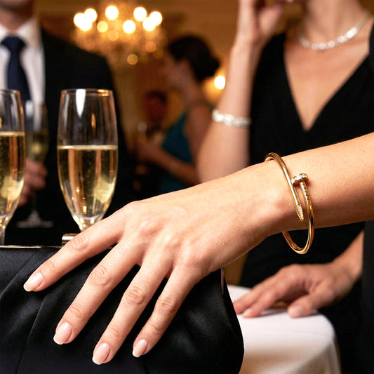 Woman wearing gold pave nail bangle styled with a black evening dress and clutch.