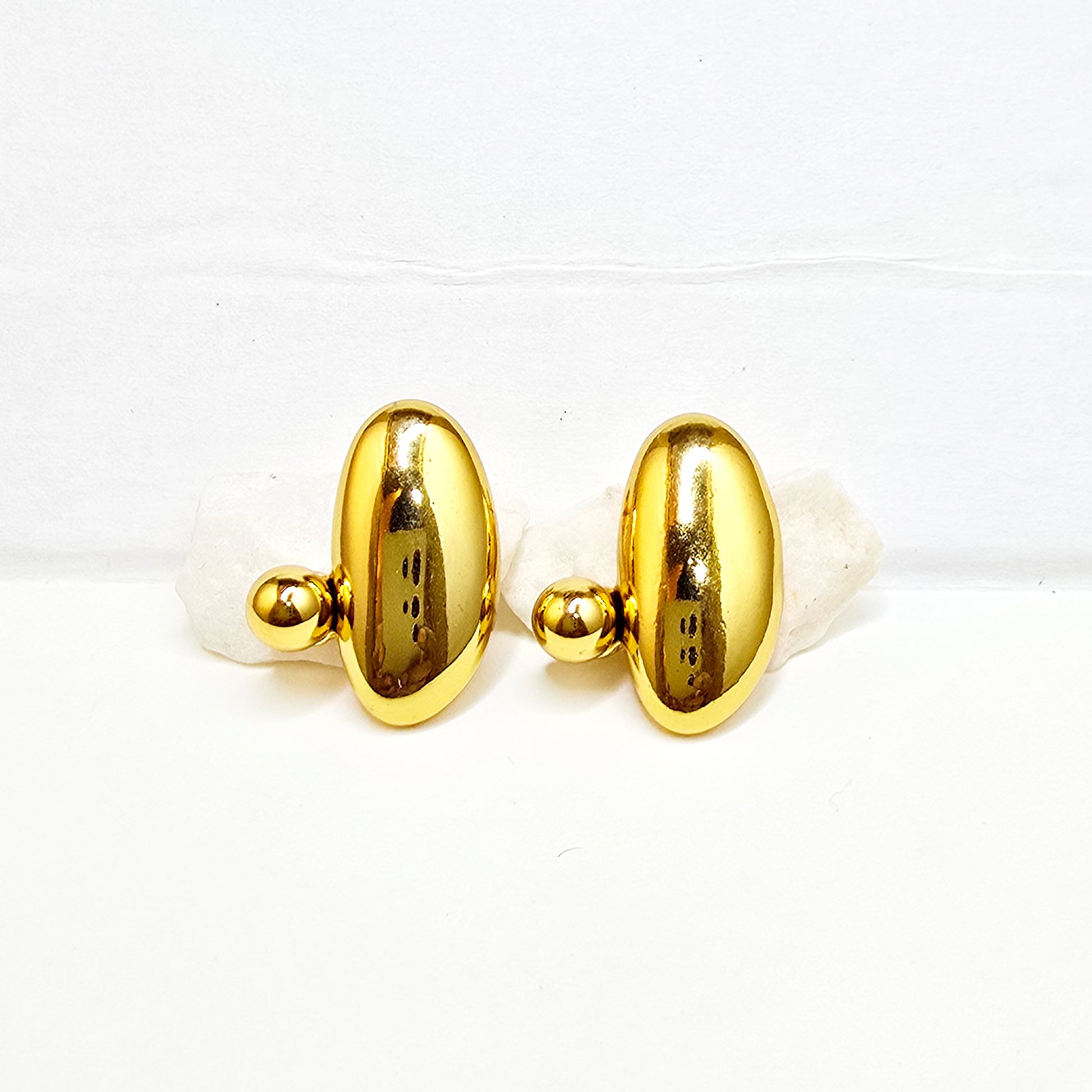 A pair of gold-plated Pebble sculptural stud earrings with a high-polish oval and sphere design on white rocks.