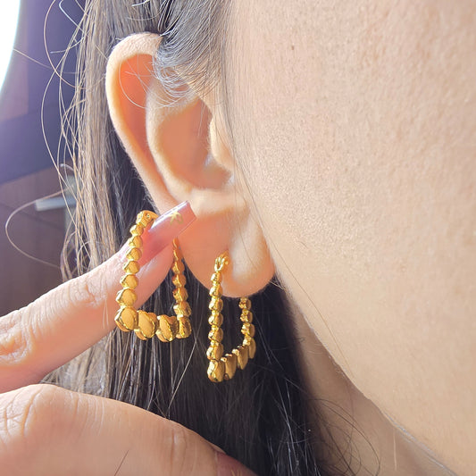 Rectangle Heart Hoop Earrings – close-up of model wearing gold heart-accented geometric hoops