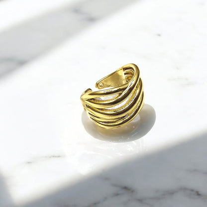 Gold Ripple Band Ring in angled light, emphasizing layered ripples and glossy finish.