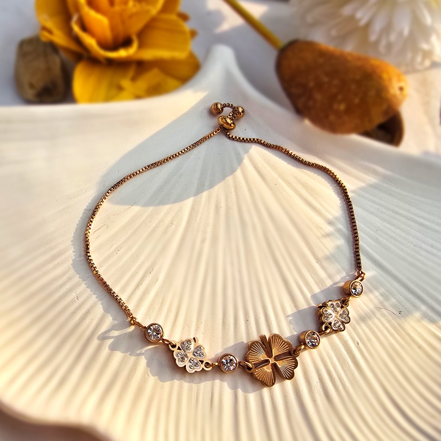 Flat lay of Serendipity bracelet with black clover charm on a white shell tray.