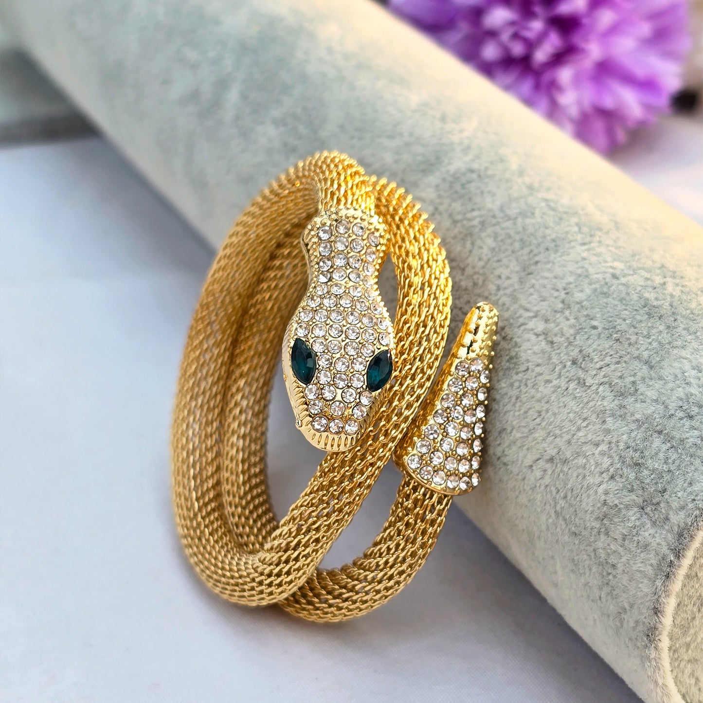 Front view of gold snake bracelet showing wrapping tail and crystal details.