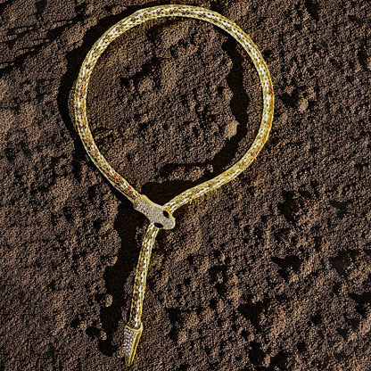 Serpent Embrace Necklace placed on textured soil background – luxury vibe