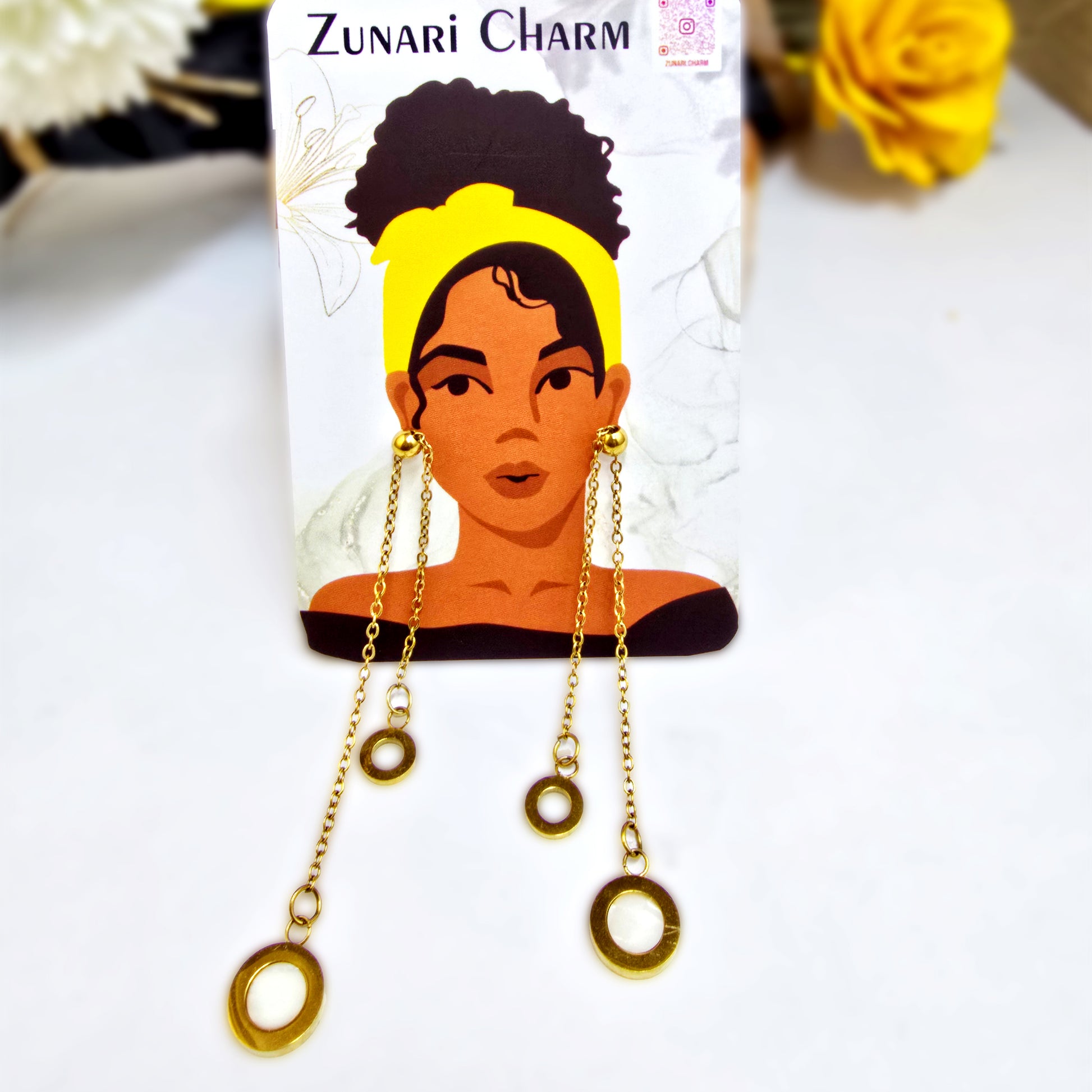 Slide Drop gold earrings displayed on a Zunari Charm branded card featuring an illustrated woman with a yellow turban.