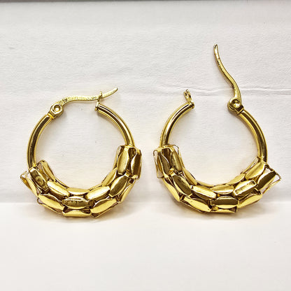 Snake Scale Earrings – bold gold textured hoops on white background