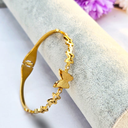 Side view of gold bangle showing repeating star patterns and crystal accents.