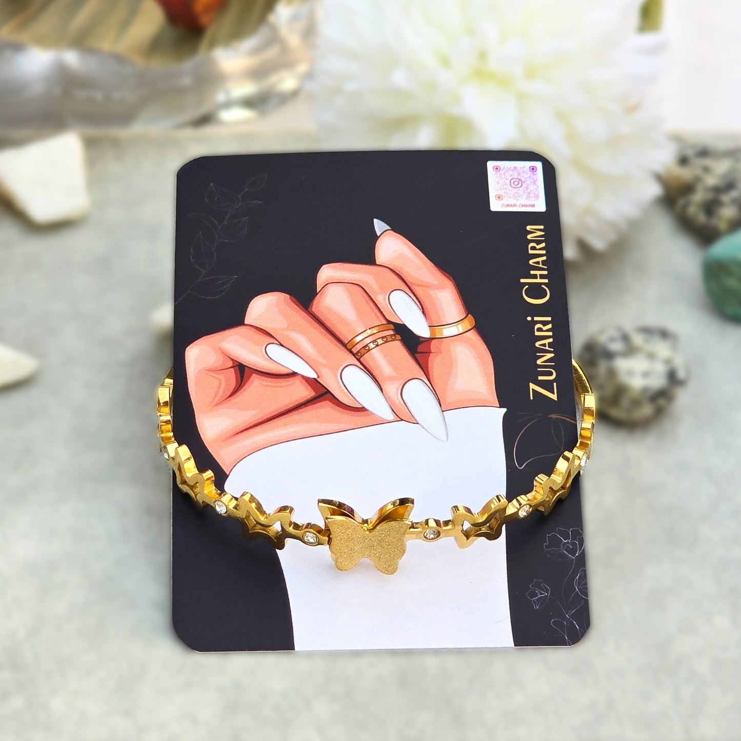 Stardust butterfly bangle displayed on Zunari Charm branded packaging card.