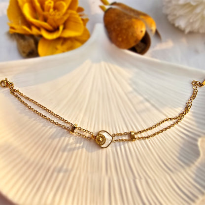 Flat lay of Starlight gold chain bracelet on a white shell tray.