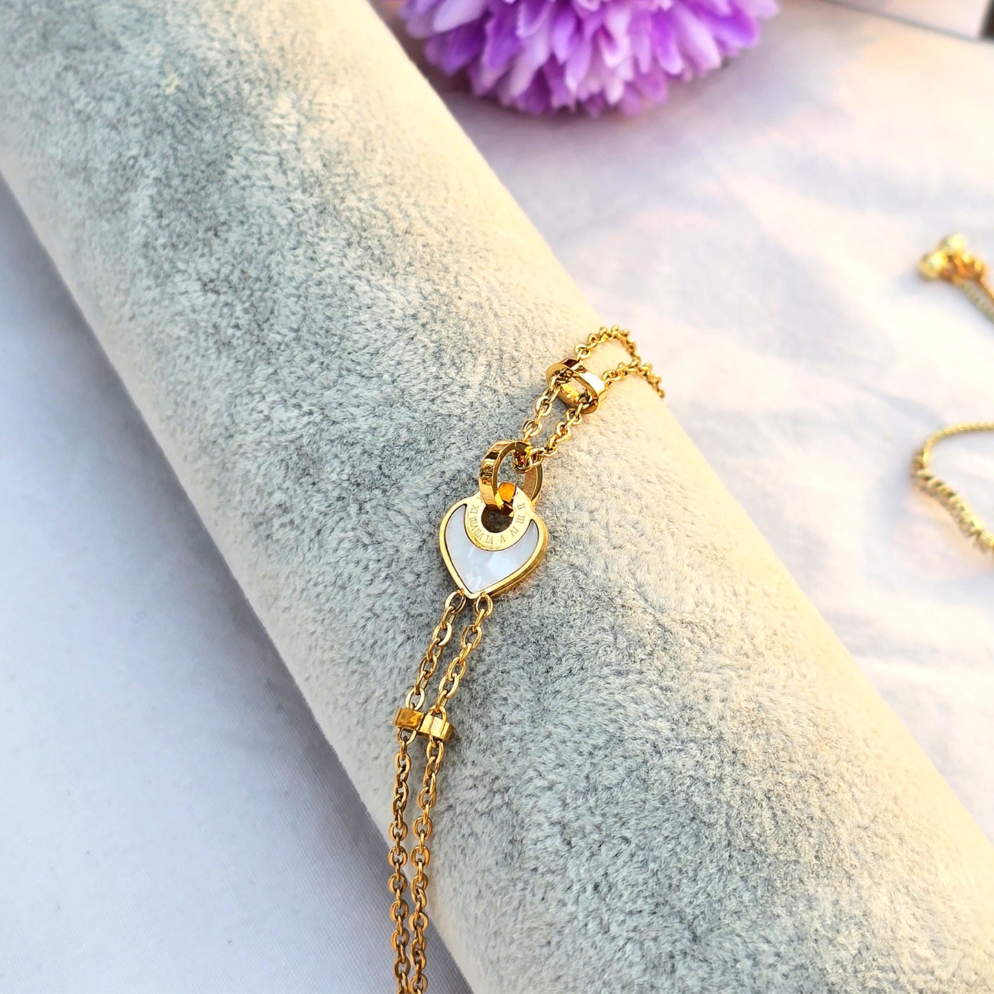 Side view of delicate gold chain bracelet showing clasp and extender.