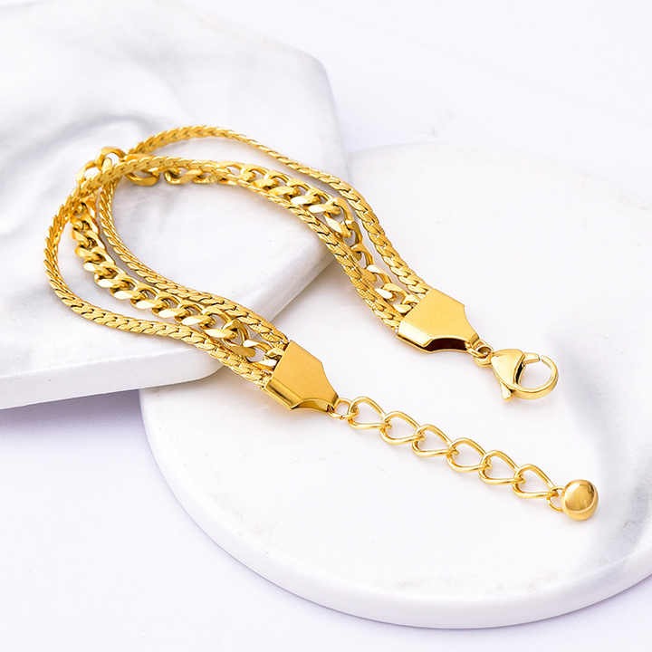 Gold chain bracelet on a white surface