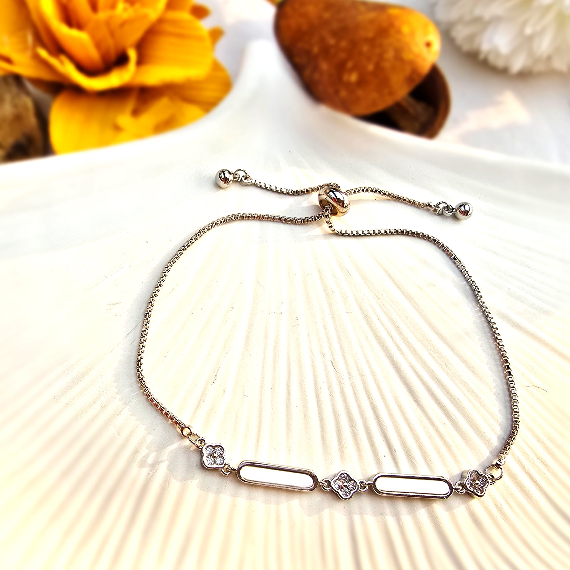 Flat lay of the silver bracelet displayed on a white shell, showing the link chain detail.