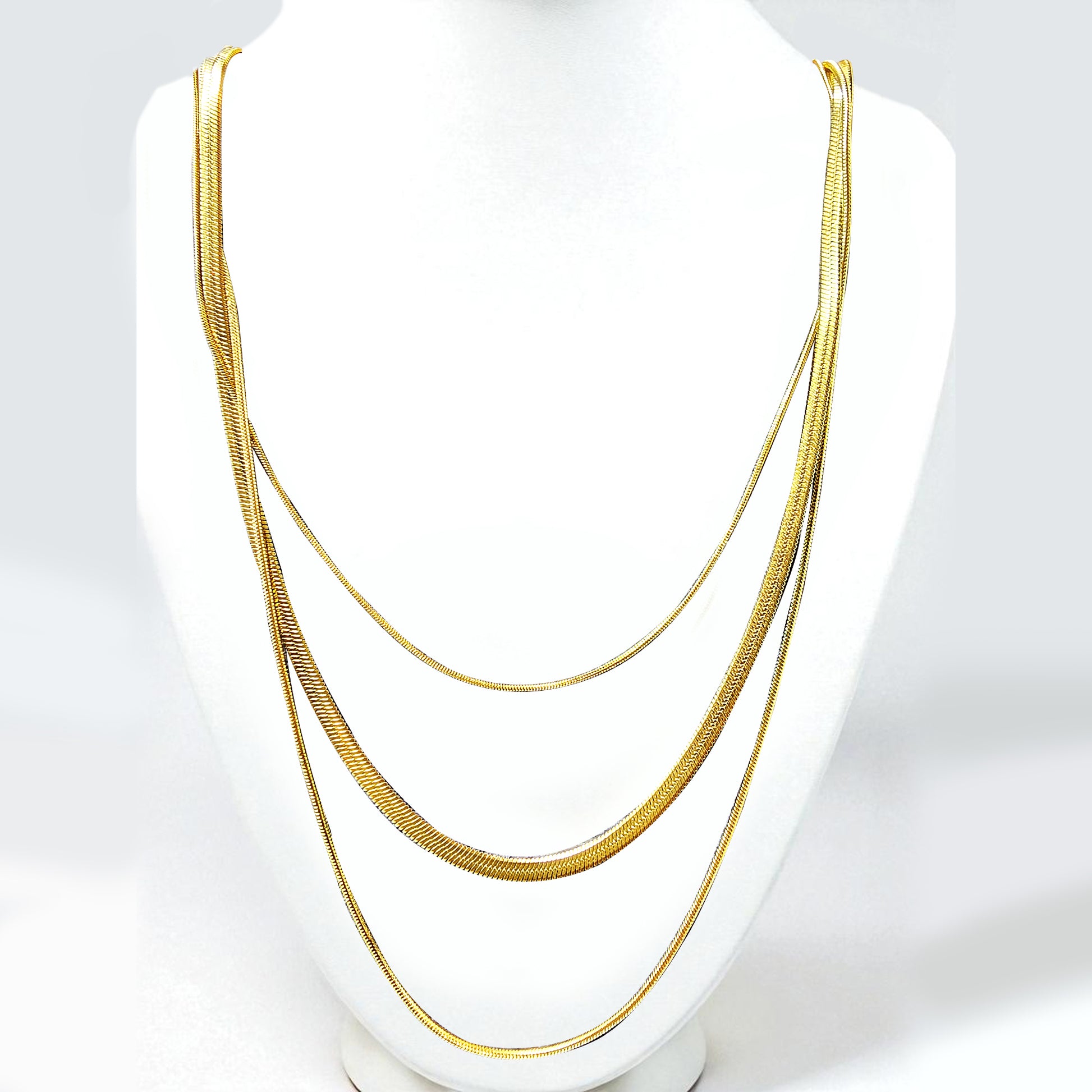 Trinity Layers Necklace displayed on a white bust stand – gold layered chains.