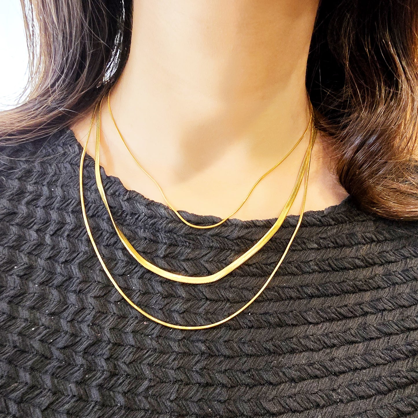 Woman wearing Trinity Layers Necklace – gold-toned layered snake chain jewelry.