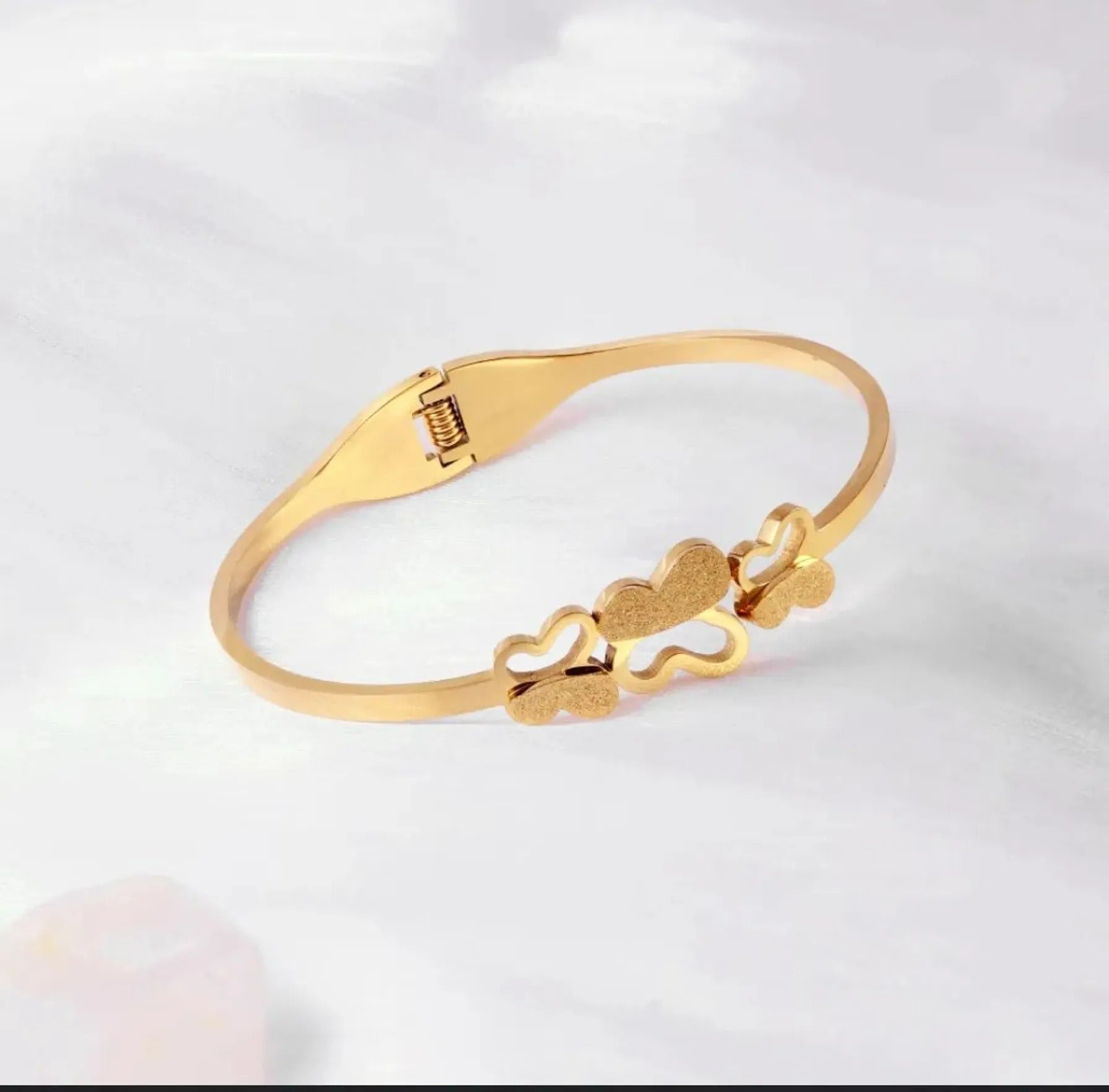 Triple Butterfly gold bracelet on white background – clasp visible